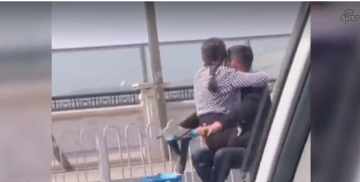 视频中,俩人相互抱着对方面对面骑行,画面一时让人无法接受.