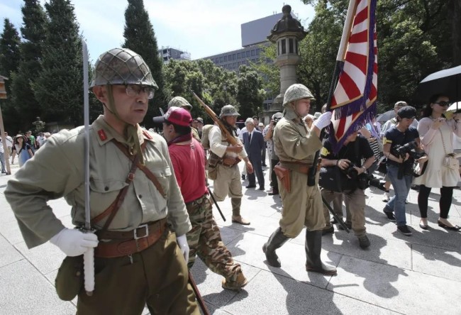 日本右翼分子穿着旧军服,扛着军旗在靖国神社游行.