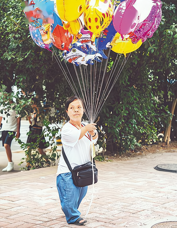 袖珍女子路边卖气球 15年资助30名学生