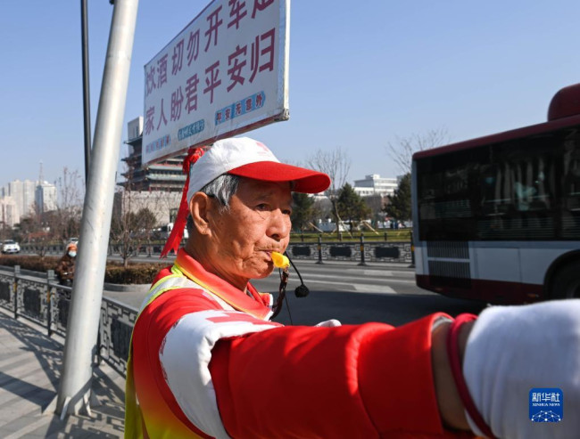 11月17日，在山西省太原市五一广场西北路口，马金明在路旁进行交通疏导。