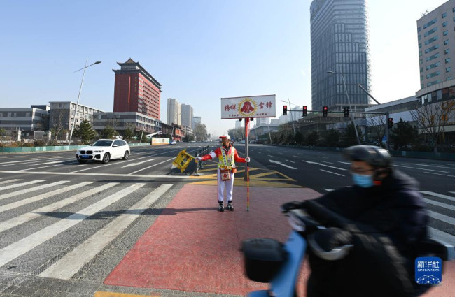 11月17日，在山西省太原市五一广场的路口，马金明在疏导交通。